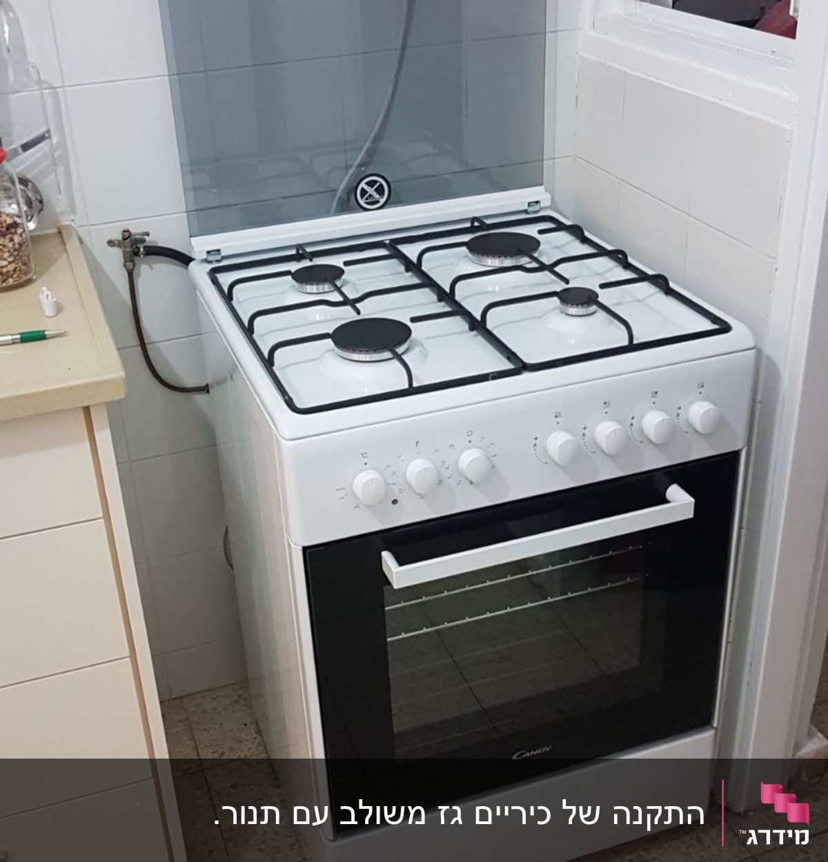 תנור גז לבן עם ארבעה מבערים ומכסה זכוכית
